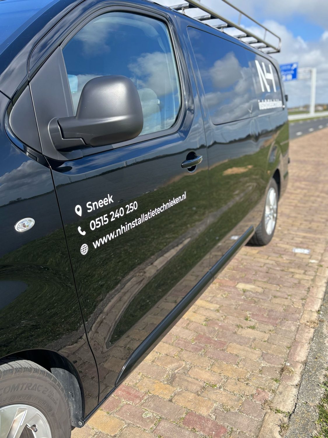Bedrijfsbus van NH Installatietechnieken, onderweg in Friesland